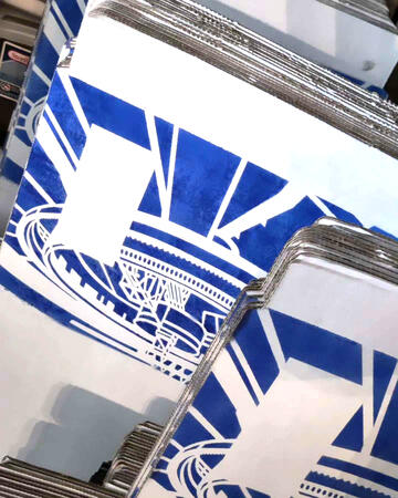 Stacks of unassembled white cardboard boxes with a simplified blueprint of Midgar painted on them. Stacks of unassembled white cardboard boxes with a simplified blueprint of Midgar painted on them.