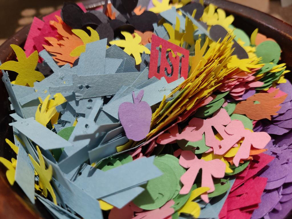 Wooden bowl with recycled construction paper confetti in various colors and shapes.